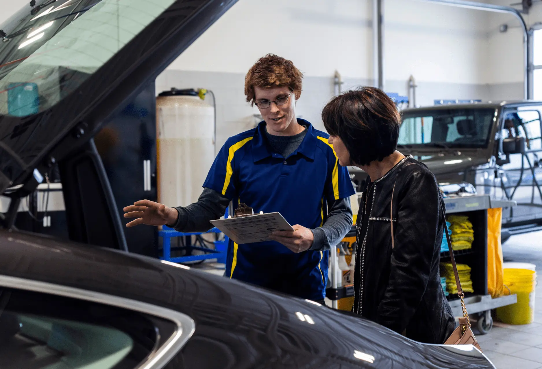 A Nathan's Detailing employee going over a vehicle with a satisfied client.